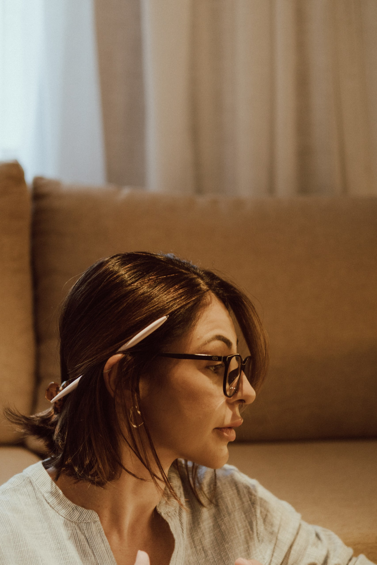 Débora Vieira Carpes de perfil, em escuta atenta durante uma sessão